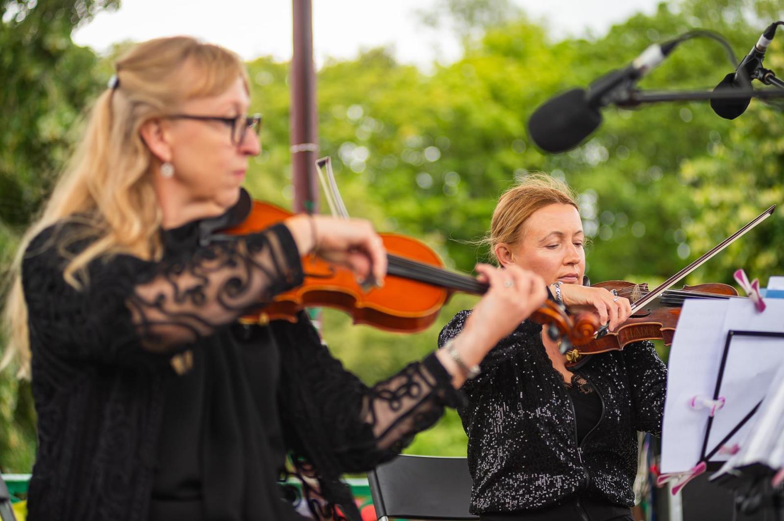 Two violins from Highly Strung's trio in action.
